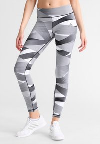 Leggings de Adidas con un patrón geométrico en blanco y negro, diseño de cintura alta y material elástico para mayor comodidad durante el movimiento.