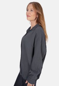 Graues Hemd mit Knöpfen aus strukturiertem Stoff, mit Kragen, langen Ärmeln und relaxed Fit. Einfaches und vielseitiges Design.