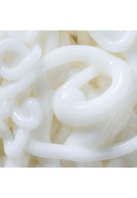 Vita plastsvängningar vävs samman, med en glänsande yta och slät yta, som bildar en dekorativ och flexibel form.