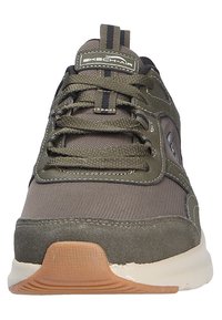 Scarpa sportiva verde realizzata in materiali come mesh, suede e gomma. Presenta un design con lacci, punta arrotondata e suola texturizzata.