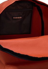 Zaino arancione con un'esterno texture, dotato di una tasca nera con zip e un rivestimento interno nero, con etichetta del marchio.