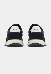 Ναυτικής μπλε παπούτσια τρεξίματος με υφή στον επάνω μέρος, λευκές λεπτομέρειες στη φτέρνα και μαύρη ελαστική σόλα. Διαθέτει δύο μικρές γκρι και μεταλλικές ρίγες.