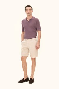 Ljuslila stickad pikétröja, beige shorts och mörkbruna loafers. Enkelt design med krage och sidorfickor på shortsen. Mjuk textur.