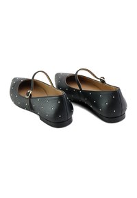 Bailarinas de cuero negro con punta afilada y tira trasera, adornadas con pequeños Studs dorados, que cuentan con una suela baja y plana.