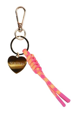 Llavero de metal con una etiqueta en forma de corazón dorado grabada con "SCALPERS" y una correa de tela trenzada en tonos rosa y naranja.