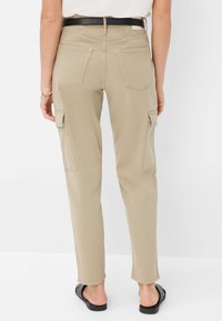 Khaki cargobroek met een slim fit, voorzien van twee zijzakken, achterzakken en een zwarte riem. De stof lijkt glad en duurzaam.