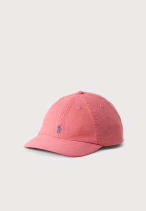 Casquette de baseball rose à visière courbée et logo bleu brodé sur le devant, posée sur un fond clair et uni.