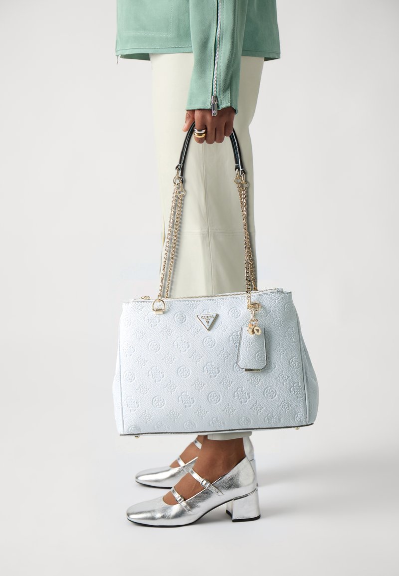 Helle blaue Handtasche mit strukturierter Oberfläche, goldenen Beschlägen und einem abnehmbaren Anhänger. Besitzt doppelte schwarze und goldene Kettenriemen.