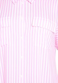 Pink striped blouse with a button-up front, short sleeves, and two chest pockets. Fabric has a smooth texture and features alternating light and dark stripes.