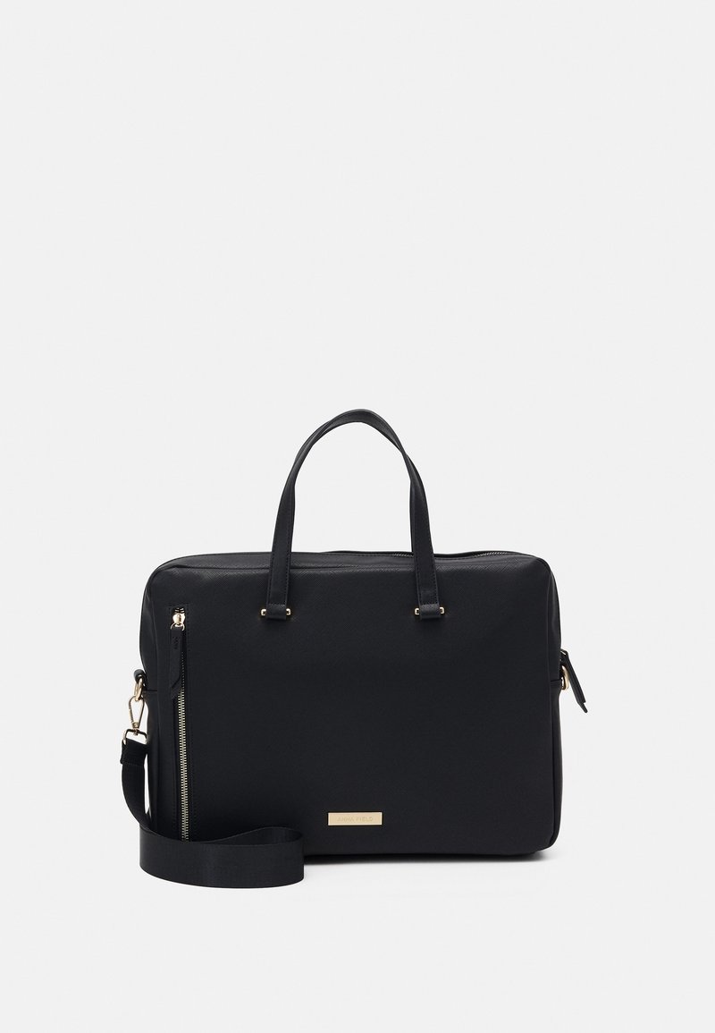 Mallette rectangulaire noire avec doubles poignées, bandoulière amovible, poche avant zippée verticale et ferrures dorées sur fond blanc.