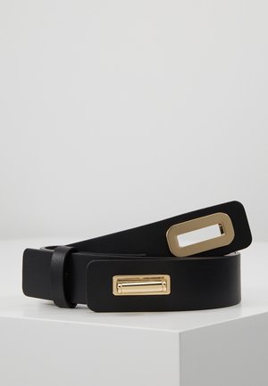 Cintura in pelle nera con fibbia rettangolare in tono oro e clip abbinata in tono oro, esposta arrotolata su una superficie bianca.