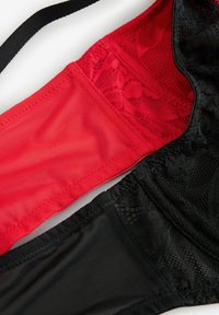 Zwarte kant en rode mesh bh, met een contrasterende textuur en ingewikkelde kantdetails aan de zwarte kant en een gladde stof aan de rode kant.