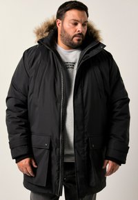 Svart parka-jacka med huvtröja foder i päls, med dragkedjestängning, framfickor och räfflade ärmslut. Slät tyg med en varm design.