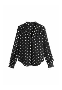 Fekete blúz fehér pöttyökkel, V-nyakú kivitel, hosszú, fodros ujjakkal mandzsetta részletekkel, sima szövet textúrával, ívelt szegéllyel.