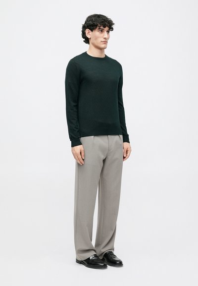 Dark green knit sweater with a crew neck, paired with light grey tailored trousers and black leather shoes, featuring a straight fit design.