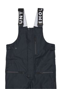 Salopette impermeabile nera con spalline regolabili, diverse tasche con zip e bottoni, e un tessuto testurizzato. Presenta il logo sulla fascia.