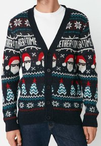 Cardigan blu navy con bottoni, decorato con facce di Babbo Natale con occhiali da sole, alberi di Natale, fiocchi di neve e la frase "Insieme! Tempo" sul petto.