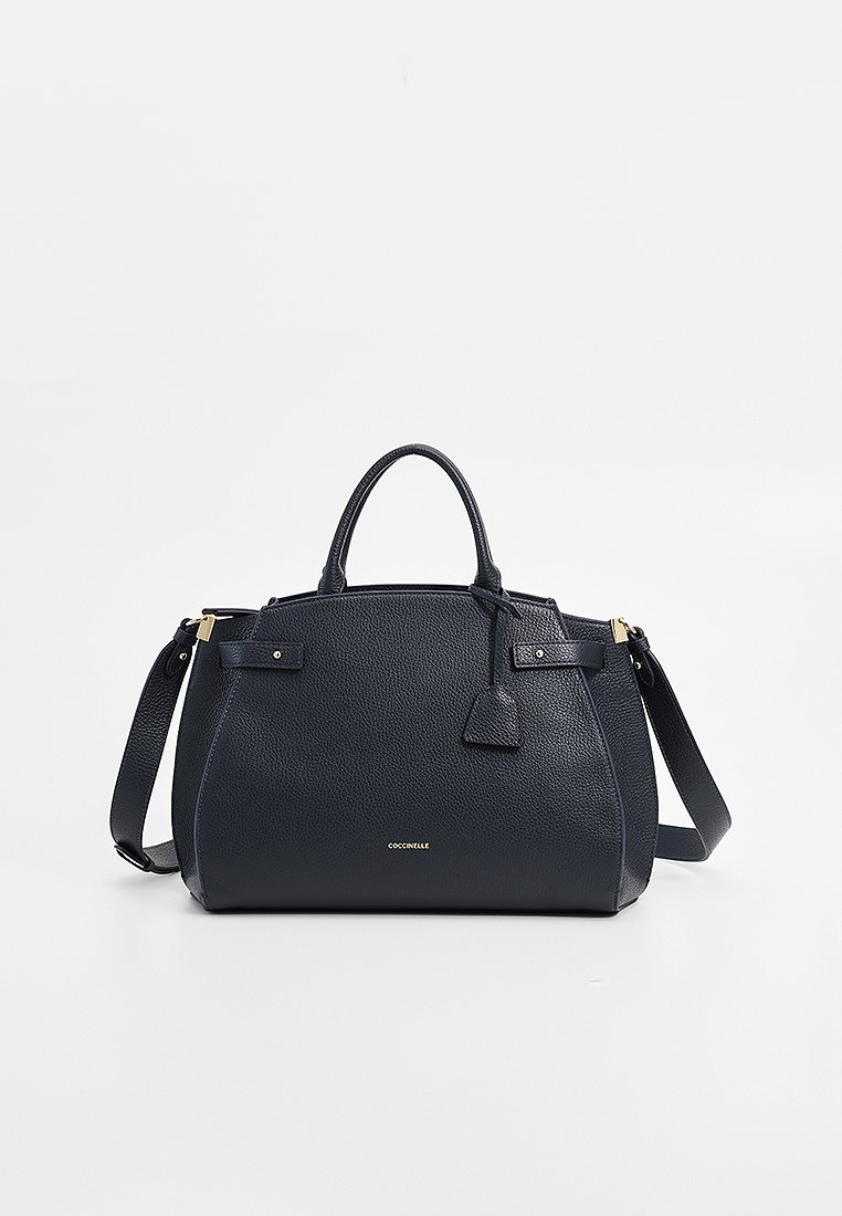 Dunkelblaues strukturiertes Lederhandtasche mit doppelten Griffen, abnehmbarem Schultergurt, goldenen Beschlägen und einem kleinen Anhänger an der Seite.