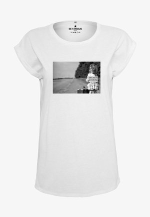 White t-shirt with rolled sleeves featuring a black and white graphic of a girl holding a sign. Text on the sign reads "take me to wonderland."