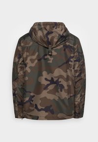 Kamuflagejakke i nuancer af grøn, brun og sort; har hætte, sømløst design og justerbart udstyr ved halsen.