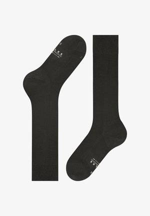 Een paar zwarte kniekousen met geribbelde manchetten en subtiele merktekst bij de tenen en enkels.