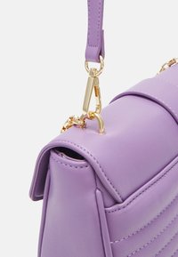 Borsa lilla in ecopelle testurizzata, con accessori dorati e dettaglio a catena. Il design presenta cuciture orizzontali.
