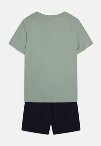 T-shirt en coton vert clair à manches courtes, associé à un short en coton bleu marine. Design simple, col rond et sans motifs visibles.