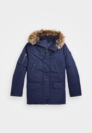 Parka de invierno azul marino con ribete de capucha de piel sintética, cierre frente con cremallera y botones a presión, dos bolsillos con solapa en la parte delantera y bolsillo con cremallera en la manga.