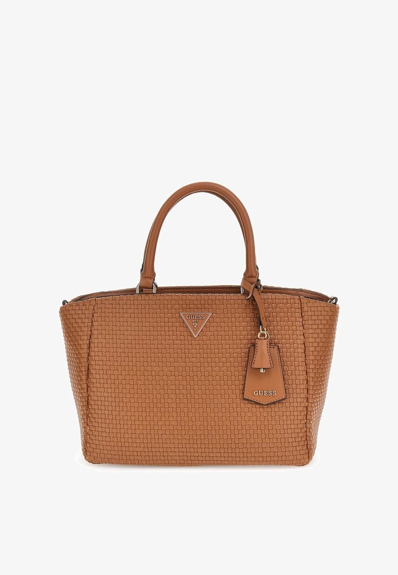Sac à main en cuir marron texturé avec deux poignées, plaque de logo Guess au centre, et une étiquette suspendue avec l'inscription "GUESS".
