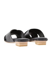 Sandali in pelle nera con design aperto, caratterizzati da un basso tacco quadrato in legno e una superficie liscia. Stile minimalista senza decorazioni.