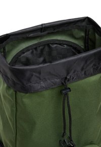Plecak w oliwkowo-zielonym kolorze z czarną górną częścią, wyposażony w zapięcie na sznurek oraz teksturowaną wewnętrzną wyściółkę, zaprojektowany z myślą o trwałości i funkcjonalności.