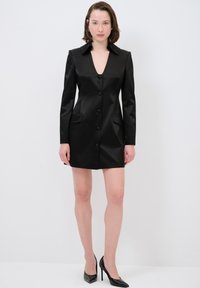 Schwarzes Satin-Kleid mit tiefem V-Ausschnitt, langen Ärmeln, zwei vorderen Taschen und Knopfverschluss. Es hat einen strukturierten Kragen und eine taillierte Form.
