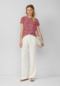 Rood gestreepte top met korte mouwen, witte wijde broek en een beige geweven tas. Glad materiaal, casual ontwerp, relaxte pasvorm.