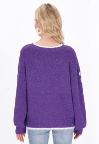 Pulover tricotat mov cu o croială lejeră, având o margine albă la guler și manșete, și un material texturat pentru căldură.