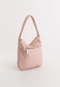 Rundet pink taske lavet af tekstureret materiale, med en enkelt strop, frontlomme med lynlås og en subtil glans.