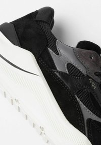 Sorte og grå sneakers i blandede materialer: suede, mesh og læder. Chunky hvid sål med struktureret greb og diskret branddetalje.