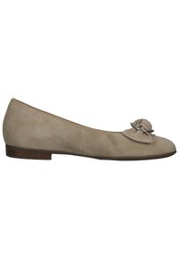 Chaussure plate en daim beige avec bout rond, petit talon en bois et fleur décorative en tissu avec anneau argenté sur le dessus.