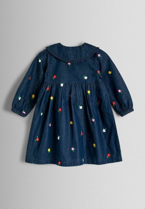 Jeansowa sukienka z długimi rękawami, haft kwiatowy w kolorach czerwonym, żółtym i białym. Posiada falbankowy kołnierz i marszczoną talię.