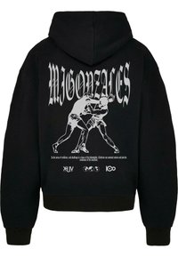 Čierna mikina s kapucňou s grafickou potlačou dvoch postáv boxujúcich, s nápisom "MIGONZALES" v veľkom bielom písme nad nimi. Mäkká textúra látky.