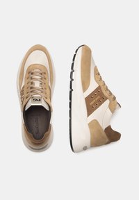 Sneakers beige e crema con materiali in suede e pelle. Design con lacci, collo imbottito e accenti a contrasto. Suola in gomma con trazione.
