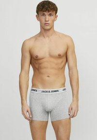 Grijze boxershorts met een zwart-witte elastische tailleband met merk, met een strakke pasvorm en een soepele textuur. Geen extra patronen zichtbaar.
