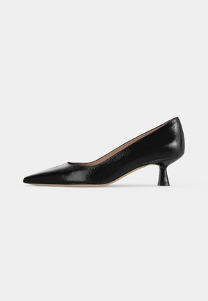 Escarpin en cuir verni noir à petit talon, bout pointu et talon fin légèrement évasé sur fond neutre.