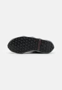 Columbia-Schuhsohle mit einem Gummiprofil für Trittfestigkeit, schwarzer Farbe mit strukturierter Oberfläche und einem markierten Akzent.