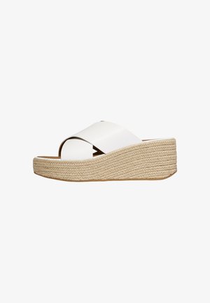 Sandale compensée blanche à enfiler avec larges brides croisées et semelle plateforme tressée texturée.