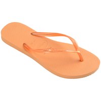 Oranssi flip-flop, jossa on teksturoitu kumipohja; läpinäkyvät hihnat, joissa on hieman kiiltoa ja logoyksityiskohtia. Kevyt ja litteä muotoilu.