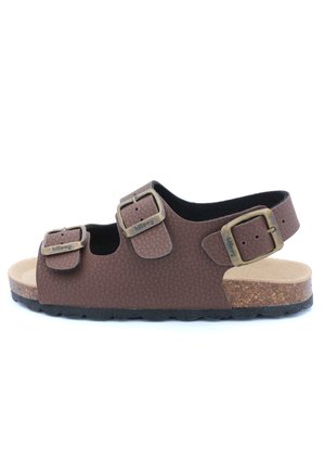 Sandale marron texturée avec deux sangles réglables et boucles en bronze. Semelle en liège et semelle en caoutchouc foncé pour plus de confort et de stabilité.
