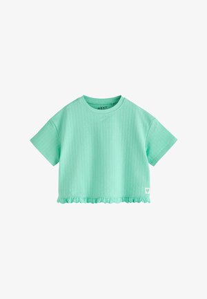 Mündirohelise värviga lühikeste varrukatega soonikkoes lühike t-särk ümmarguse kaelusega ja voltidega servaga, mille all paremal on väike südamekujuline logo.