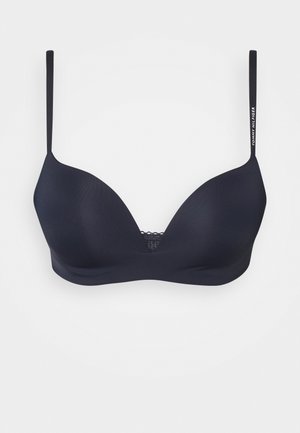 Navy padded bra with lace detail at the center, thin adjustable straps, and a smooth finish. Features brand logo on one strap.