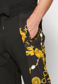 Versace Jeans Couture CHAIN - Trainingsbroek - black/gold