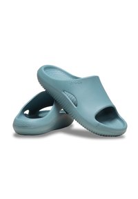 Zoccoli di gomma azzurri chiari con design open toe, suola testurizzata e bordi curvi. Presentano una finitura liscia e dettagli laterali intagliati.
